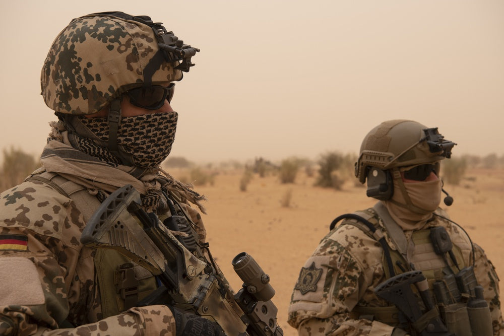 German Bundeswehr soldiers assess a group of Mauritanian troops as they dismount their vehicles