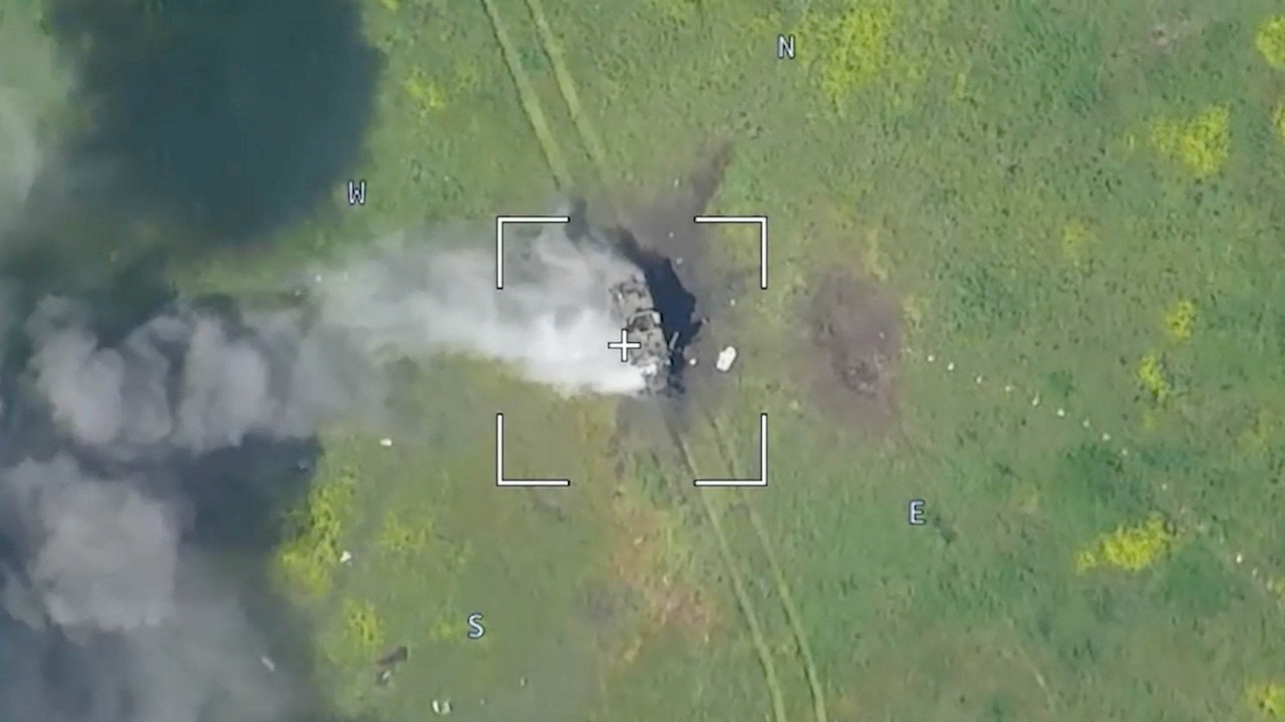 Drone footage shows a burning armored vehicle in an unidentified location after the Defence Ministry in Moscow