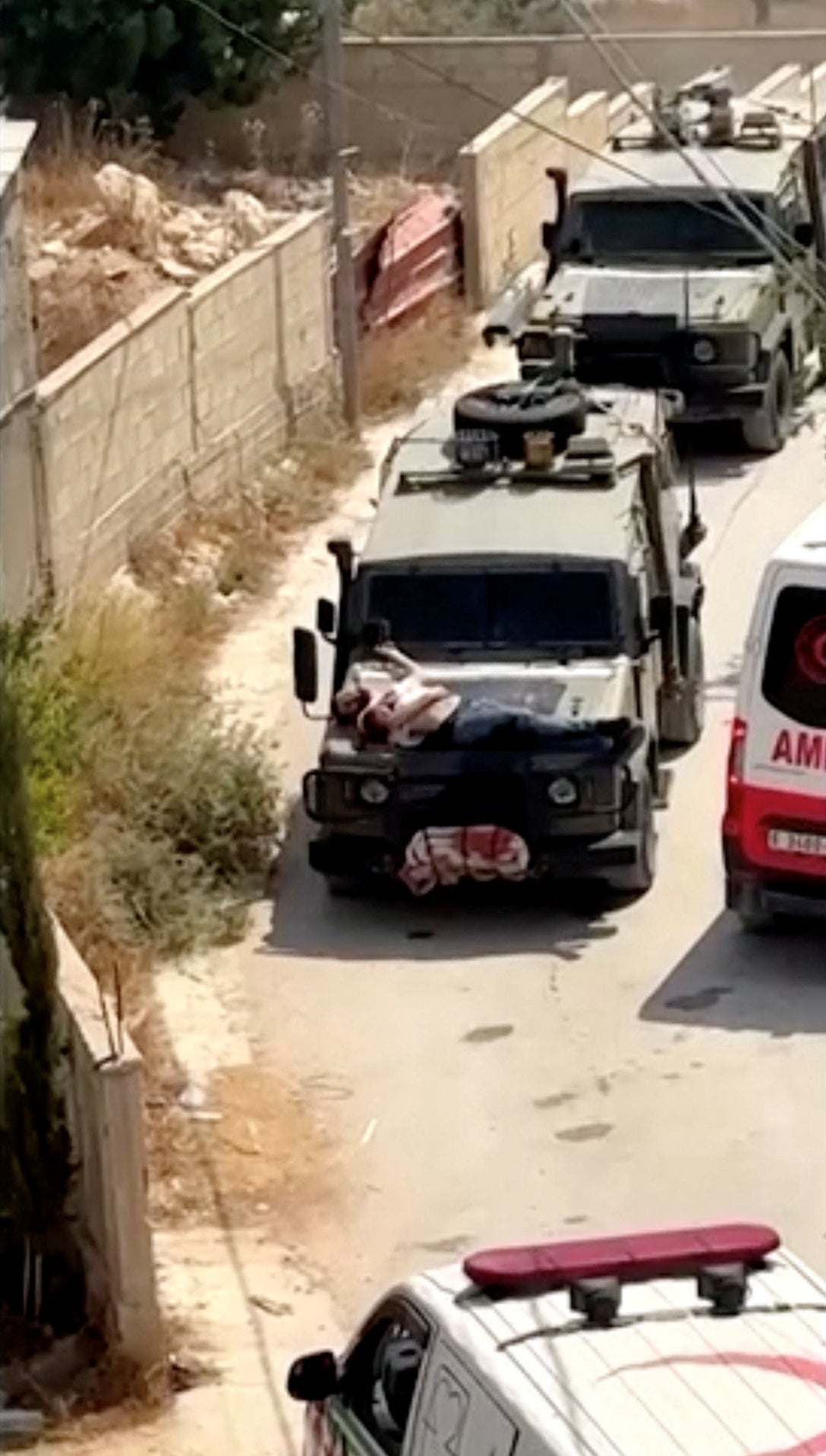 Israeli forces strap wounded Palestinian to vehicle during raid