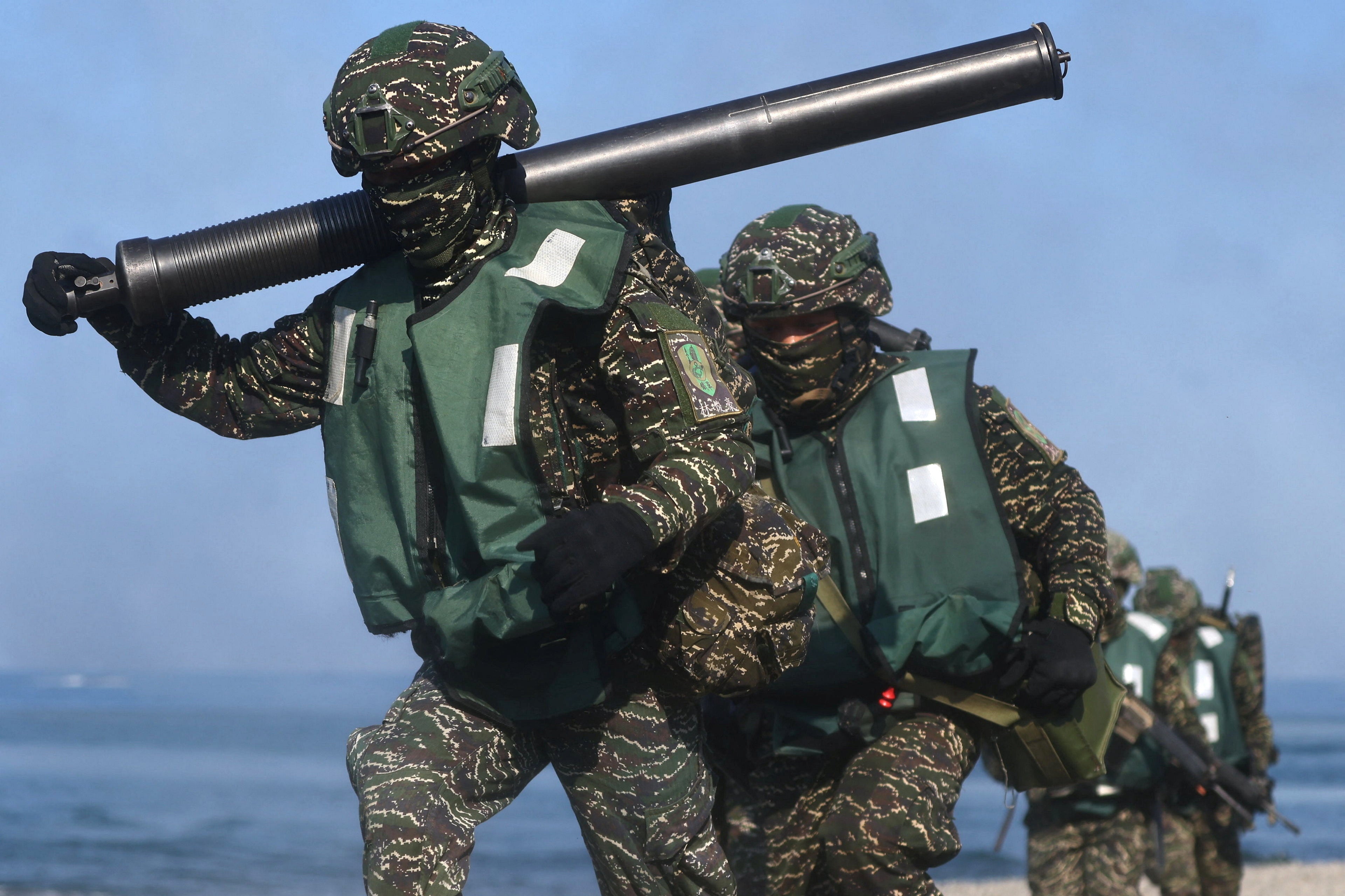 Soldiers exit from AAV7 amphibious assault vehicle run to position during an Amphibious landing drill as part of the Han Kuang military exercise in Pingtung, Taiwan