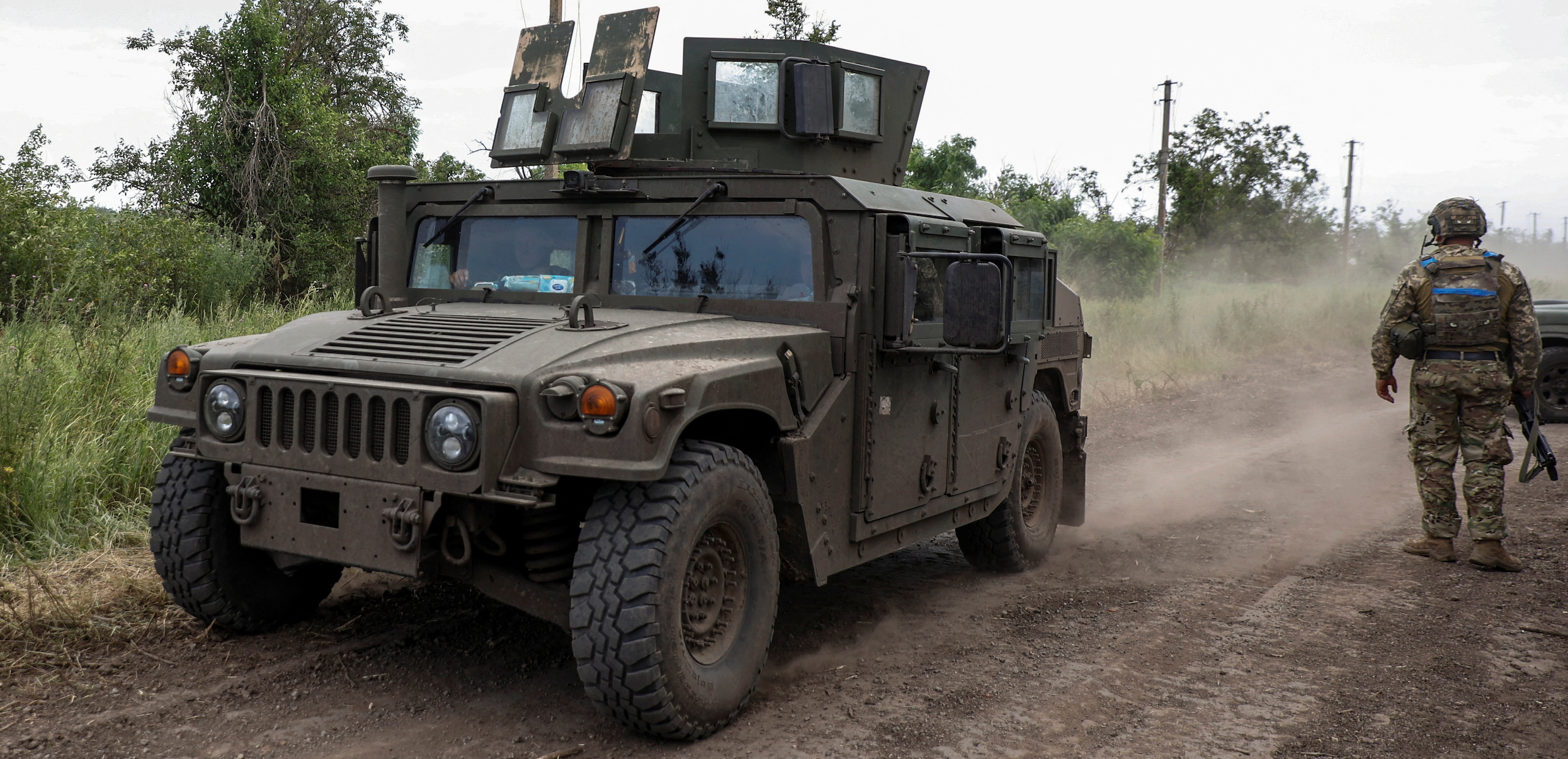 A HMMWV (Humvee) vehicle moves along a road near a the recently retaken village of Novodarivka, amid Russia's attack on Ukraine