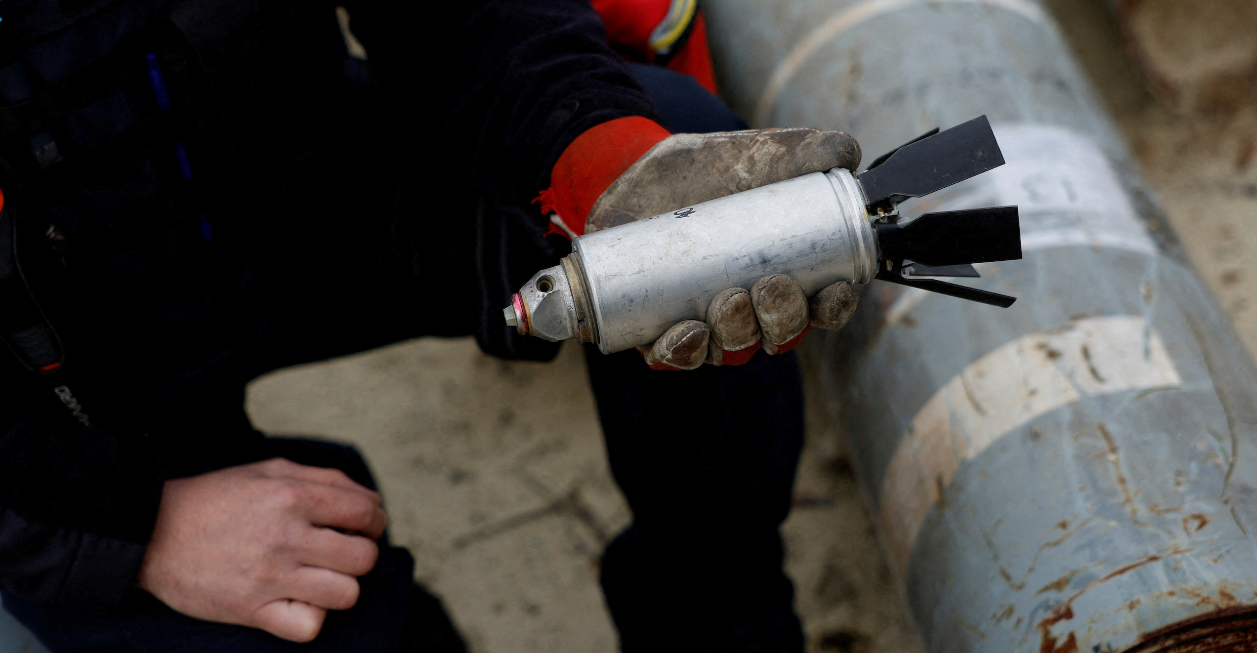 Ukrainian military serviceman Igor Ovcharruck holds a defused cluster bomb from an MSLR missile