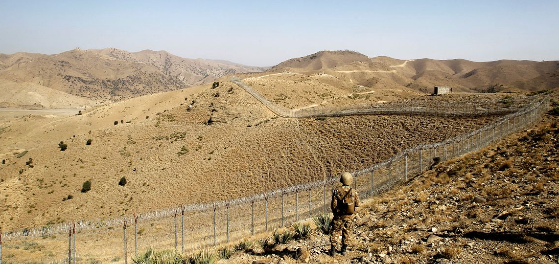 A Pakistani soldier stands guard along the border fence outside the Kitton outpost