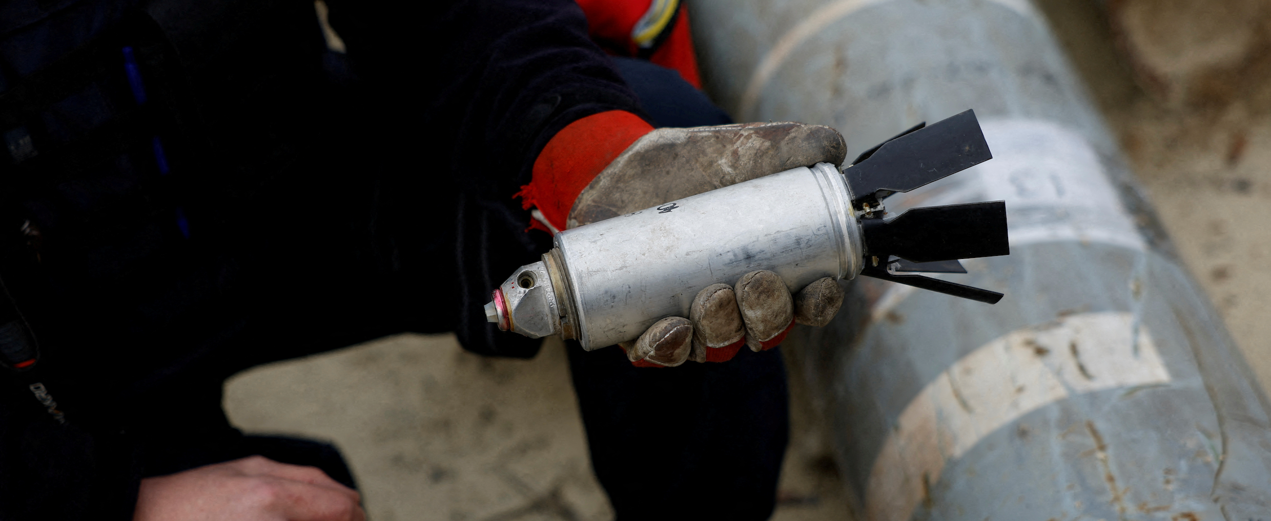 Ukrainian military serviceman Igor Ovcharruck holds a defused cluster bomb from an MSLR missile