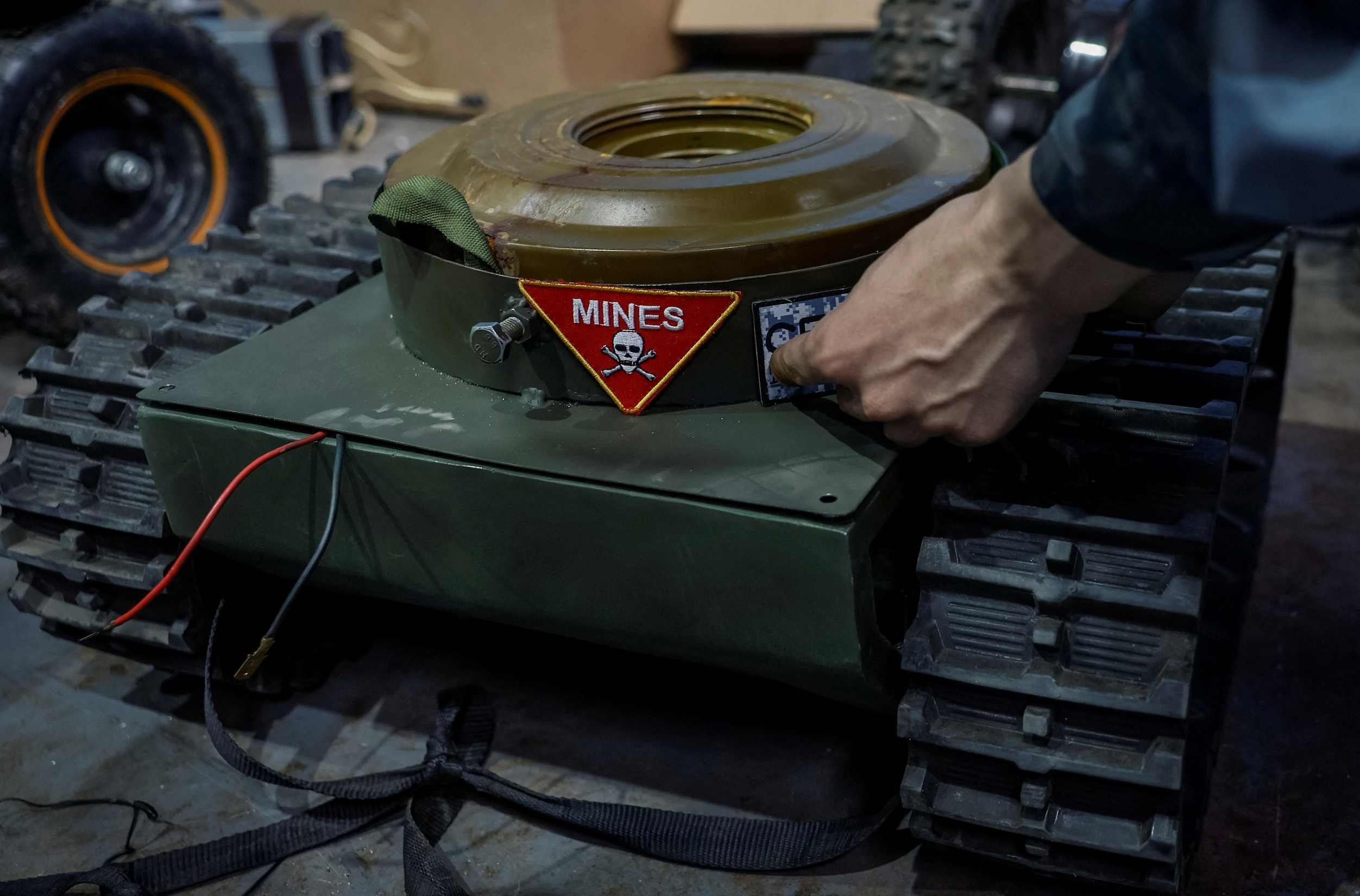 Yevhen Hnatok, 22, former Ukrainian serviceman, shows an unmanned ground vehicle, with his patches, in workshop, amid Russia's attack on Ukraine