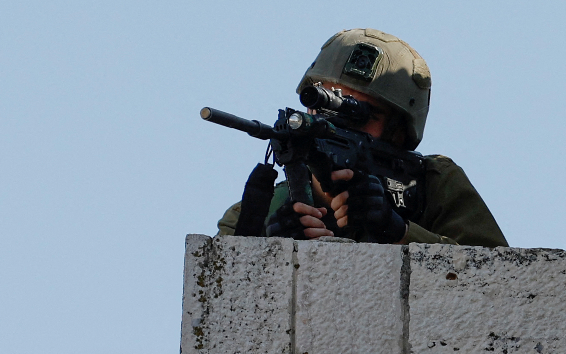 An Israeli soldier aims a weapon during clashes with Palestinians