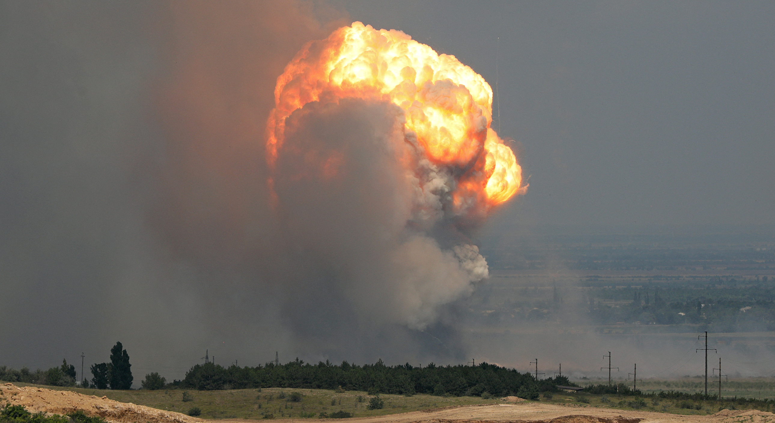 Smoke and flames rise from an explosion during a fire at a military training ground in the Kirovske district