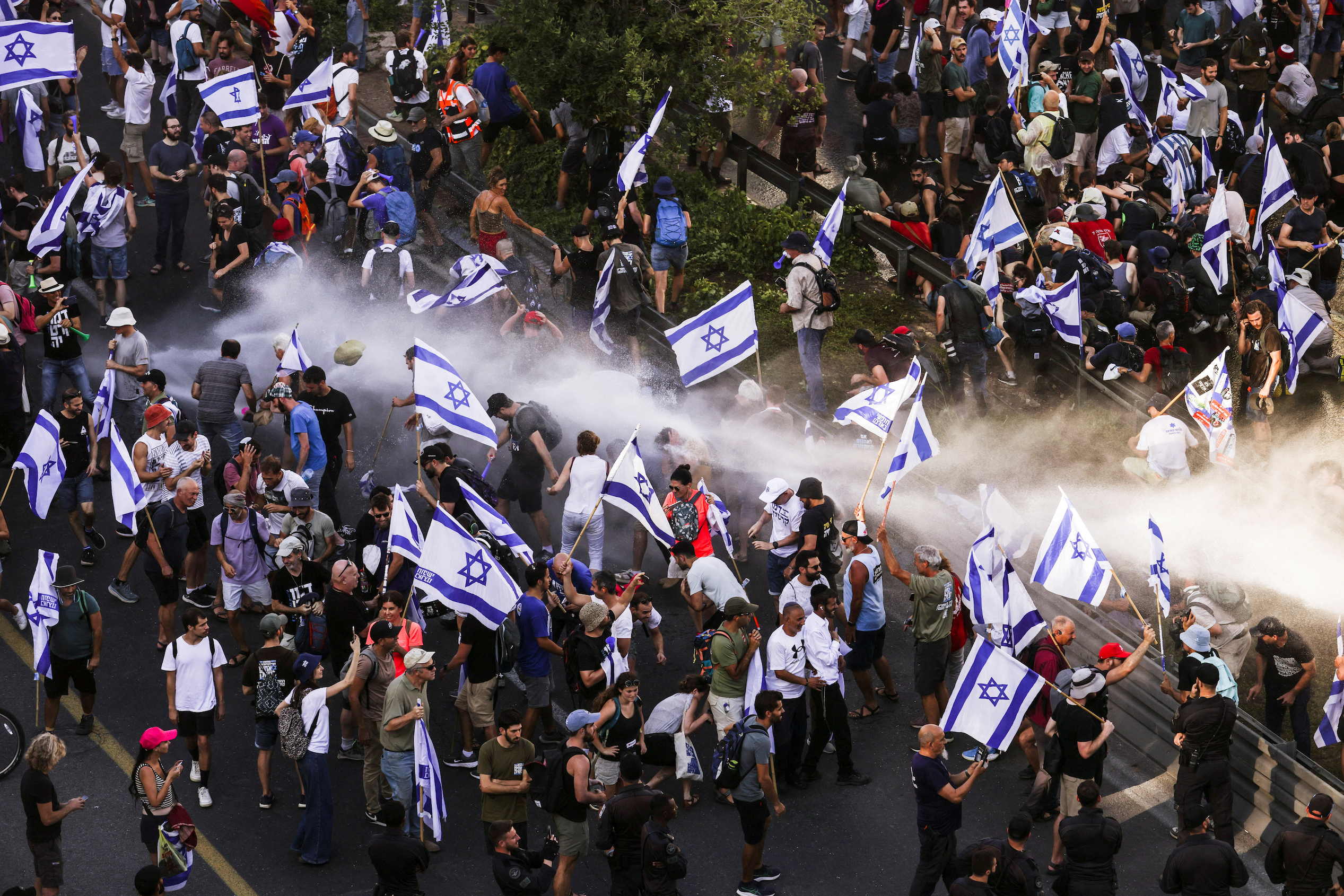 Police use a water cannon on protesters blocking a road that leads to the Prime Minister's office