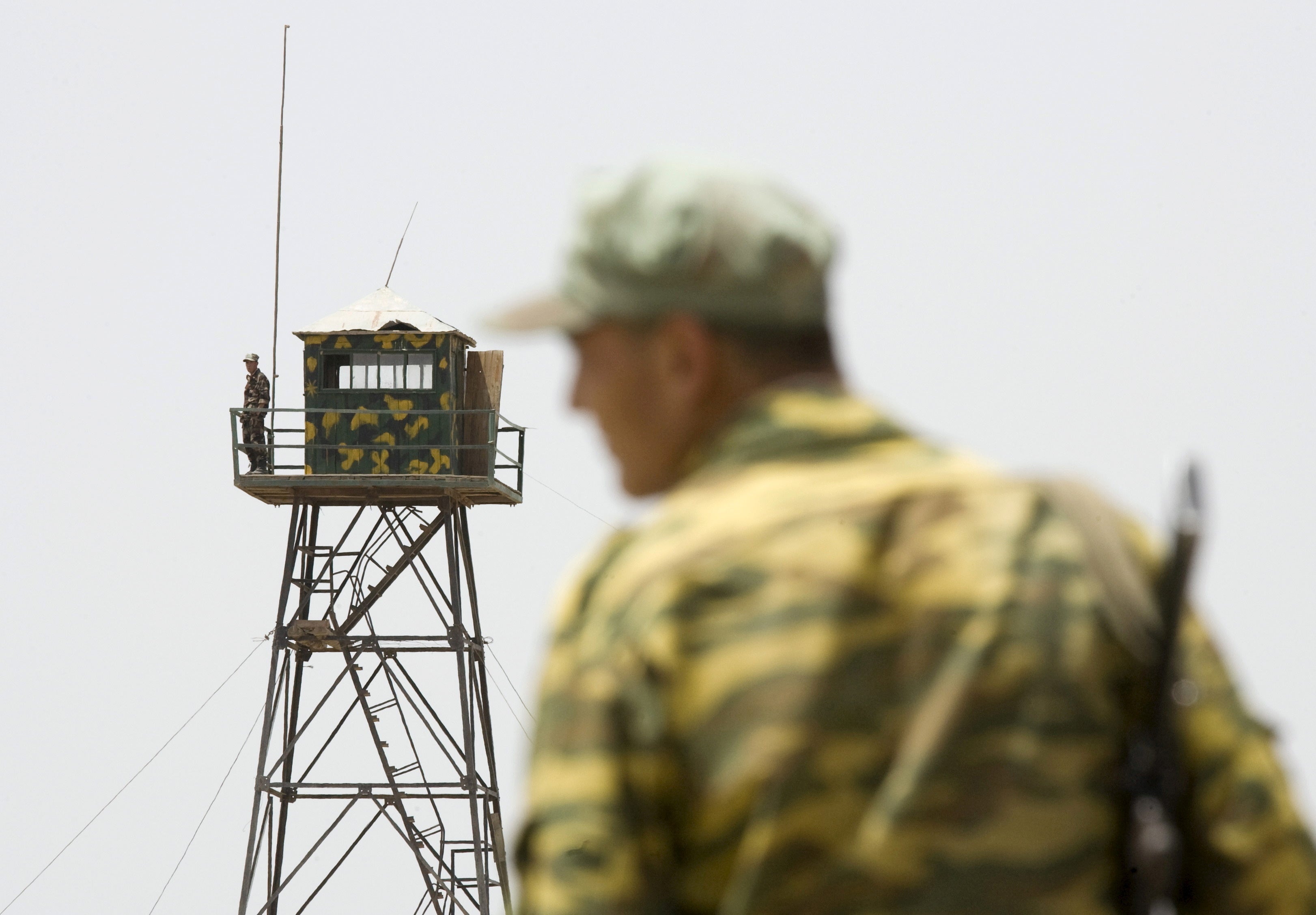 A frontier guard stands on a bridge to Afghanistan across Panj river in Panji Poyon border outpost, south of Dushanbe, Tajikistan