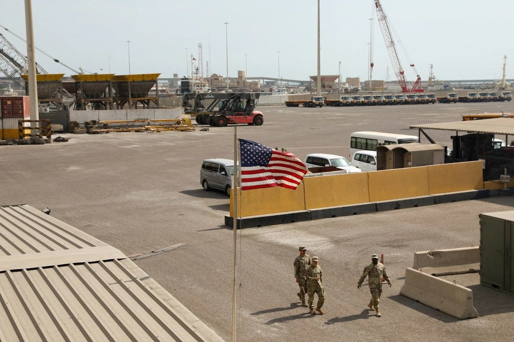 Illustrative file photo: U.S. Army soldiers walk near an American flag at the Port of Shuaiba in Kuwait on Nov. 4, 2022. An Iranian drone strike at the port on March 1, 2026, killed six U.S. Army Reserve soldiers assigned to the 103rd Sustainment