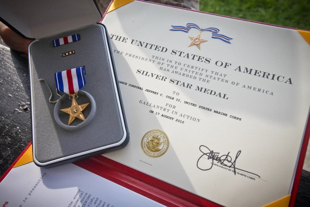A Silver Star Medal rests beside its award certificate. James Lyon admitted falsely claiming he received the Silver Star and Bronze Star despite never serving in combat. U.S. Marine Corps photo / DVIDS