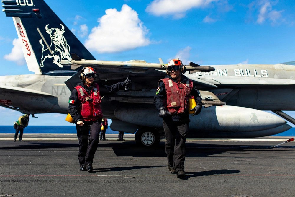 U.S. Sailors move across the flight deck of USS Gerald R. Ford after loading ordnance onto an F/A-18E Super Hornet while supporting Operation Epic Fury in the Eastern Mediterranean Sea, March 2, 2026. U.S. Navy photo.