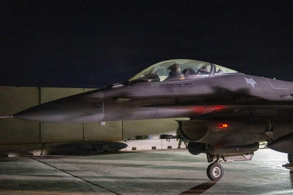 A U.S. Navy sailor directs an F/A-18E Super Hornet aboard USS George H.W. Bush while the carrier operates in the U.S. 5th Fleet area in August 2026. Iranian commanders are reportedly developing wider retaliation plans in case the United States launches