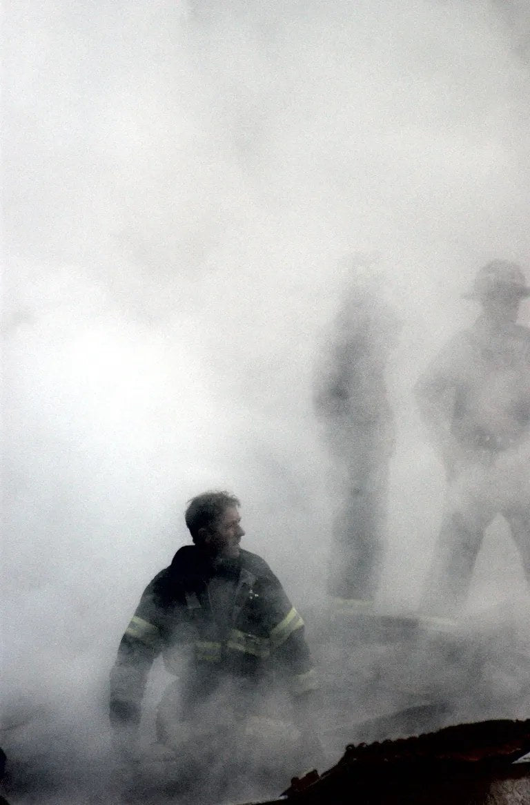 A firefighter searches through smoke and debris at Ground Zero in New York City on Sept. 14, 2001, three days after the World Trade Center attacks. U.S. Navy photo by PH2 Jim Watson/National Archives.