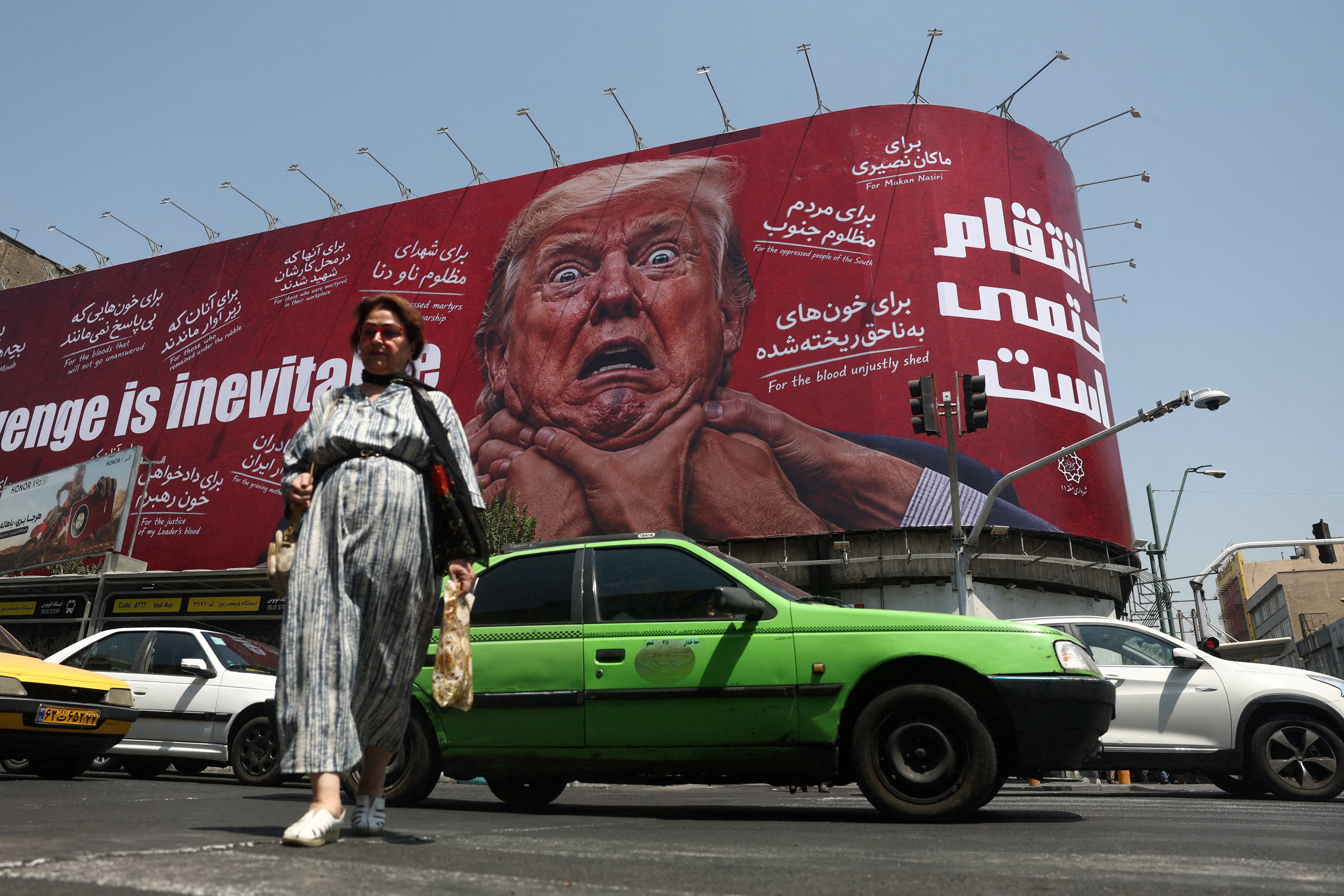 A woman walks near a billboard depicting U.S. President Donald Trump on a building in Tehran, Iran, July 27, 2026. Majid Asgaripour/WANA (West Asia News Agency) via REUTERS
