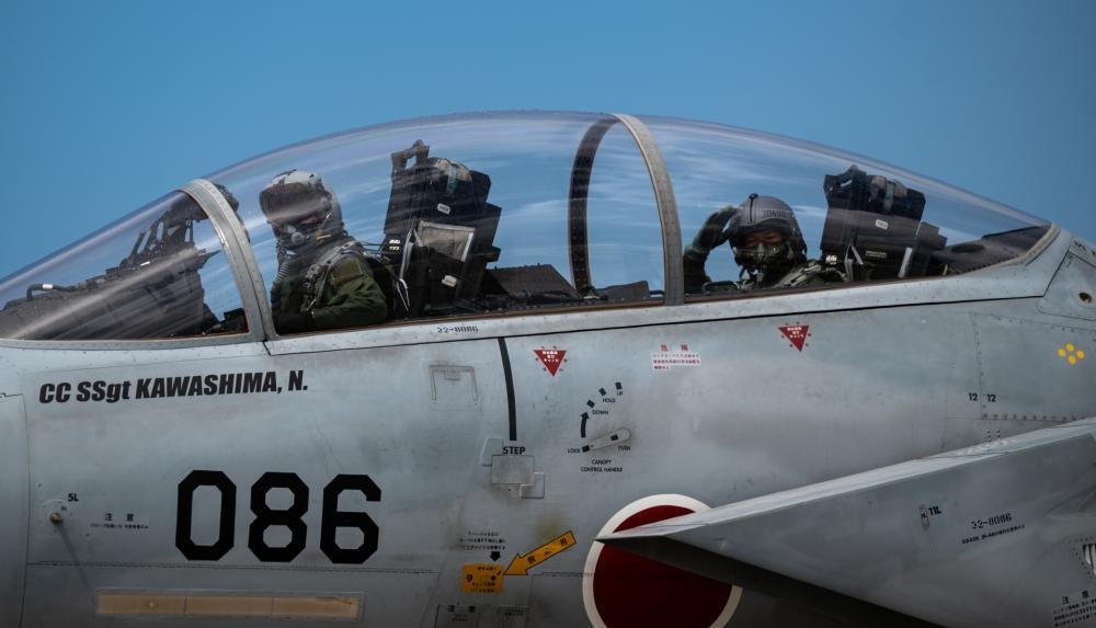 Japan Air Self-Defense Force pilots wave prior to taking off in support of Exercise Southern Beach at Naha Air Base, Japan