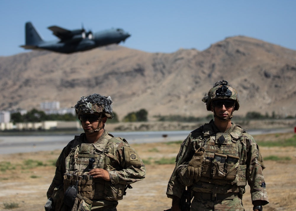 Two Paratroopers assigned to the 1st Brigade Combat Team, 82nd Airborne Division conduct security while a C-130 Hercules takes off during a non-combatant evacuation operation in Kabul, Afghanistan