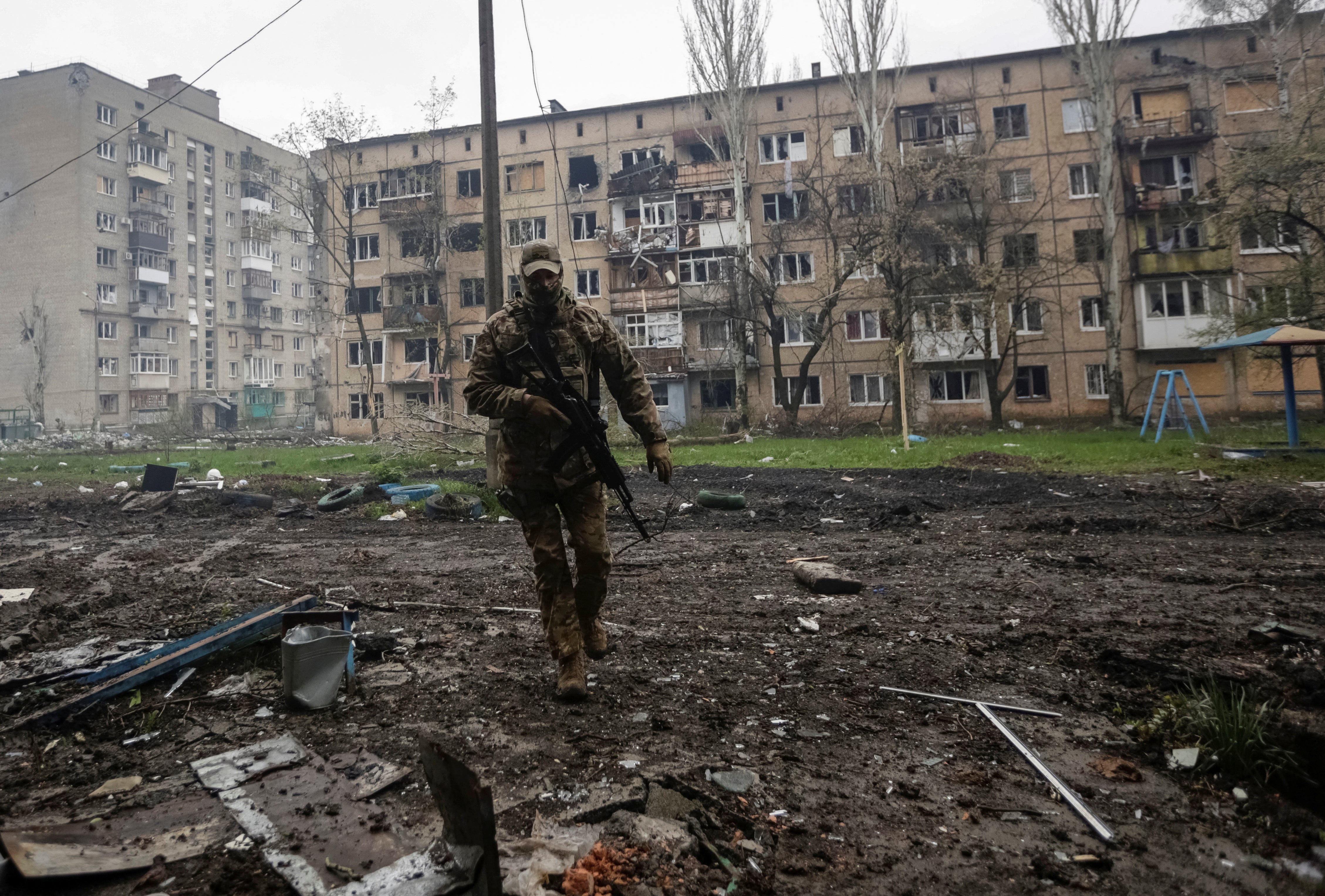 A Ukrainian service member walks near residential buildings damaged by a Russian military strike, amid Russia's attack on Ukraine, in the front line town of Bakhmut, in Donetsk region