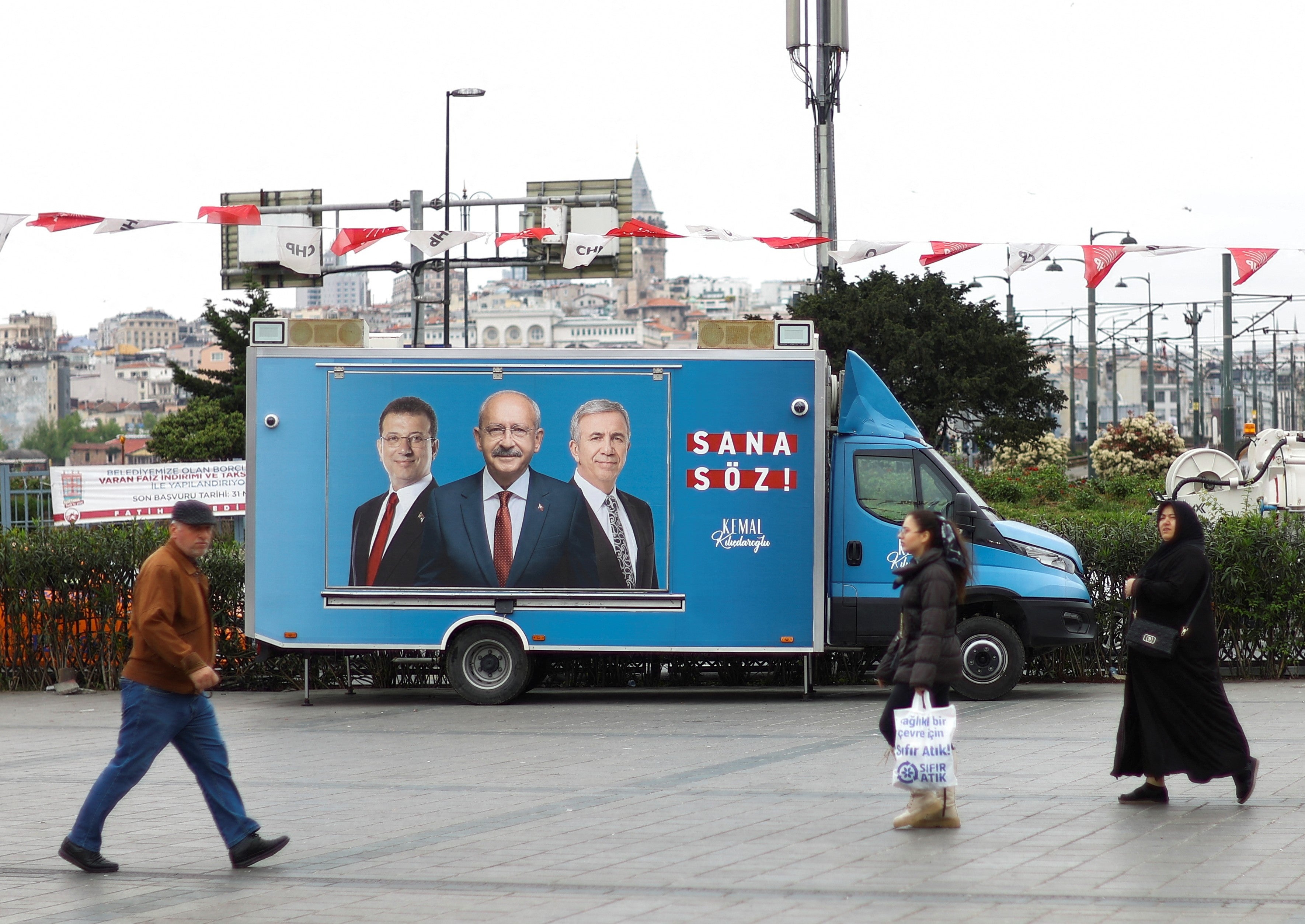 People walk past a campaign car of Kemal Kilicdaroglu, presidential candidate of Turkey's main opposition alliance