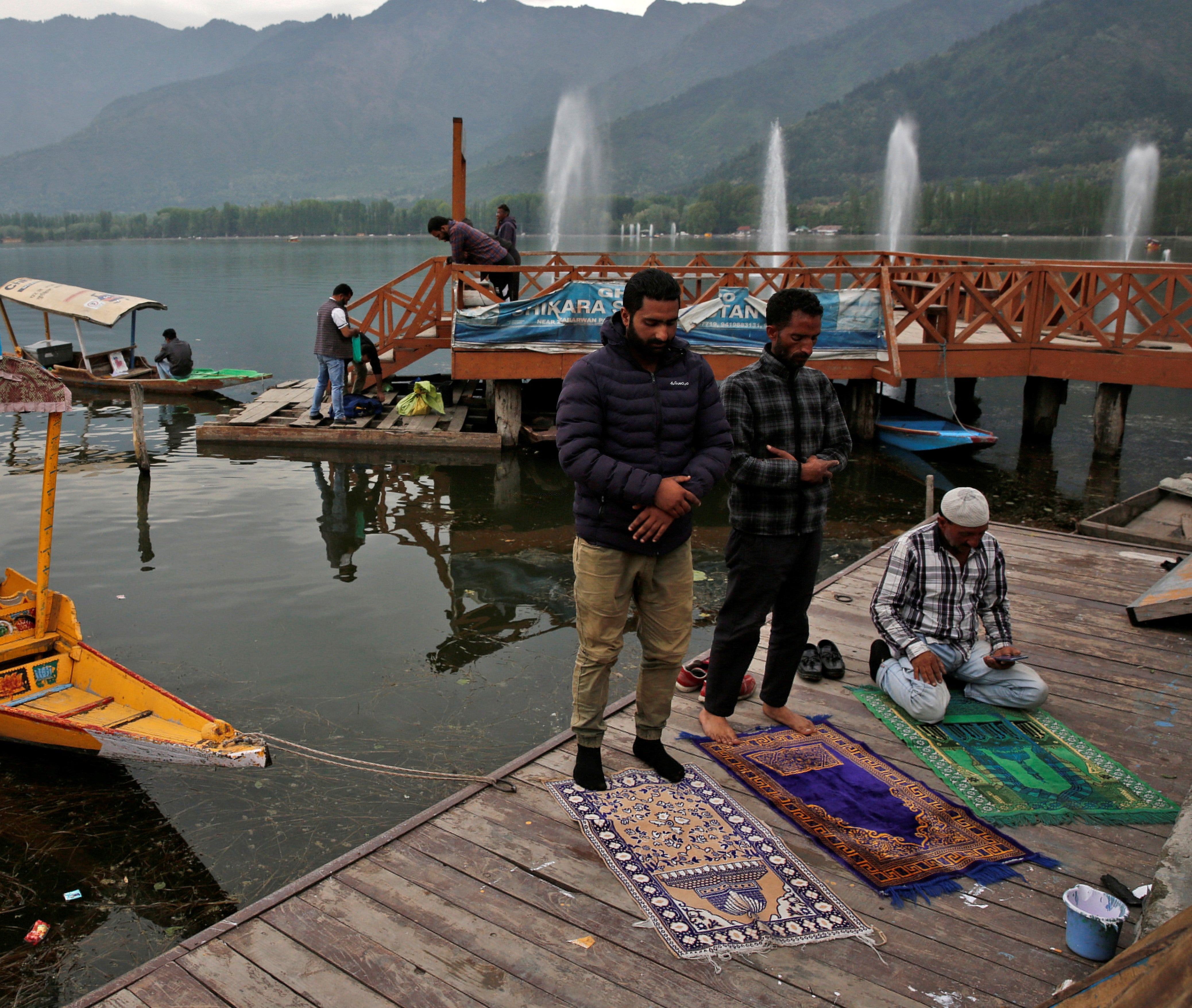 Muslim men offer prayers on the banks of Dal Lake, during the fasting month of Ramadan