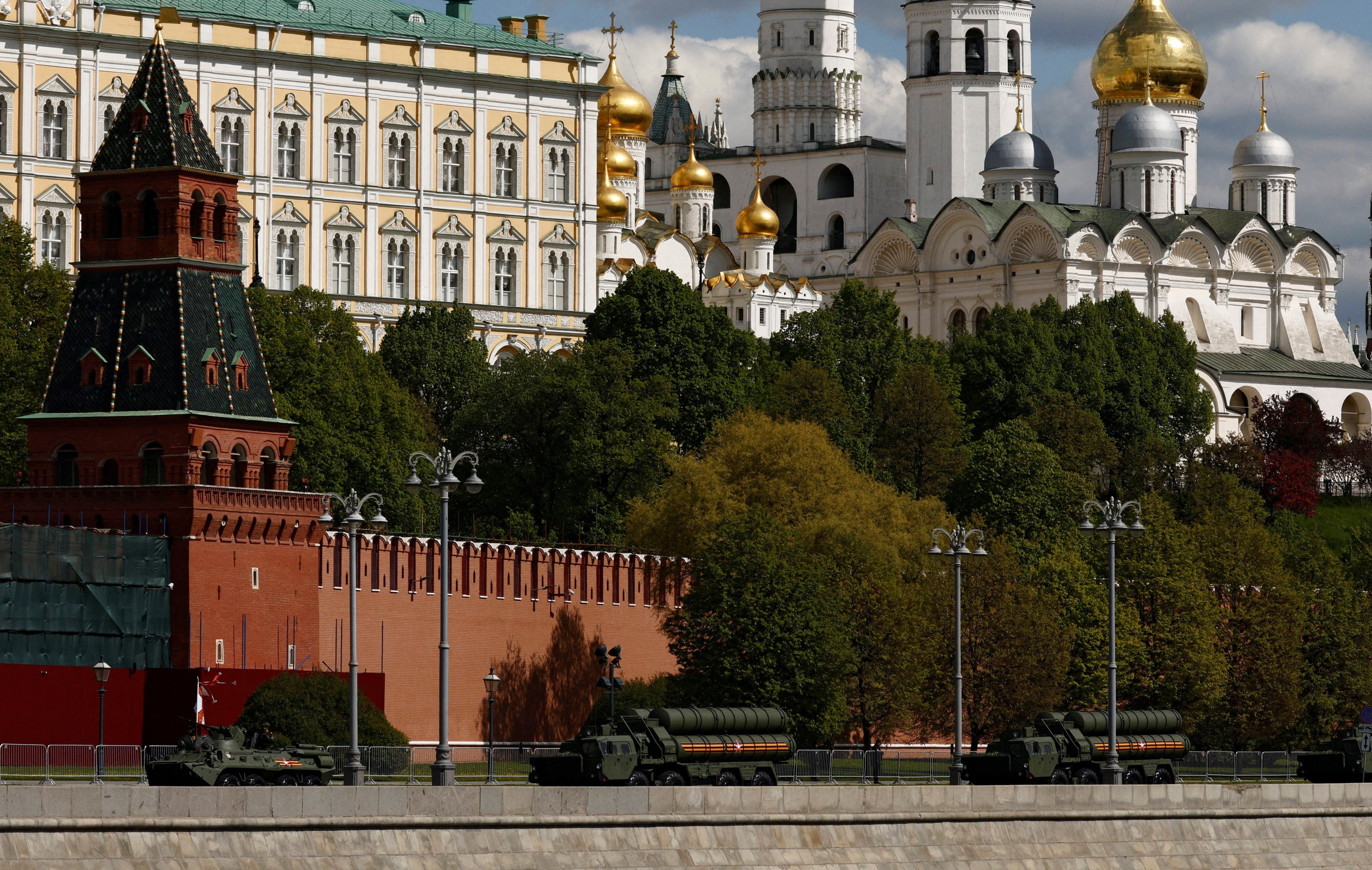 A Russian armored personnel carrier and S-400 surface-to-air missile systems drive past the Kremlin wall after a military parade on Victory Day