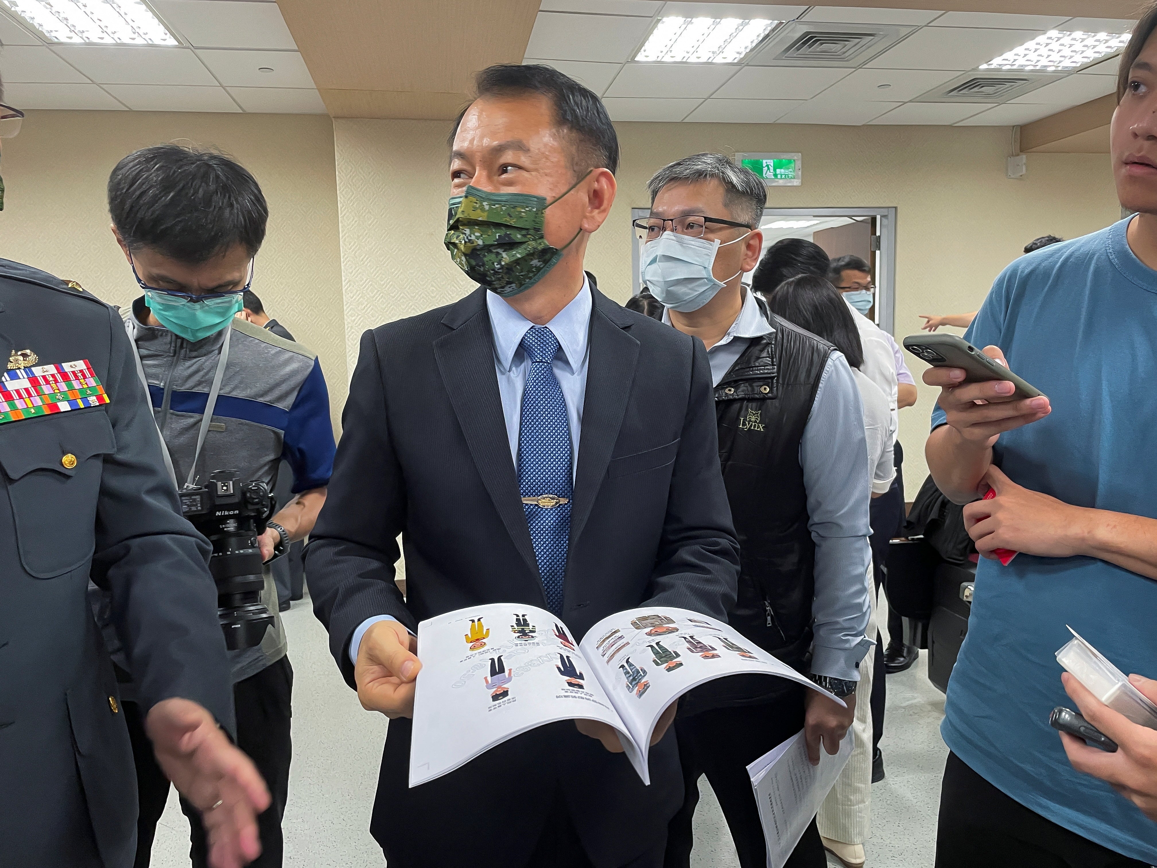 All-Out Defense Mobilization Agency Director Shen Wei-chih displays the newest version of Civil Defense Handbook