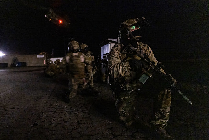 Operators from the United Kingdom Special Forces and the Ukrainian Special Purpose Unit await exfiltration via helicopter following a simulated assault on an oil rig during exercise Night Hawk