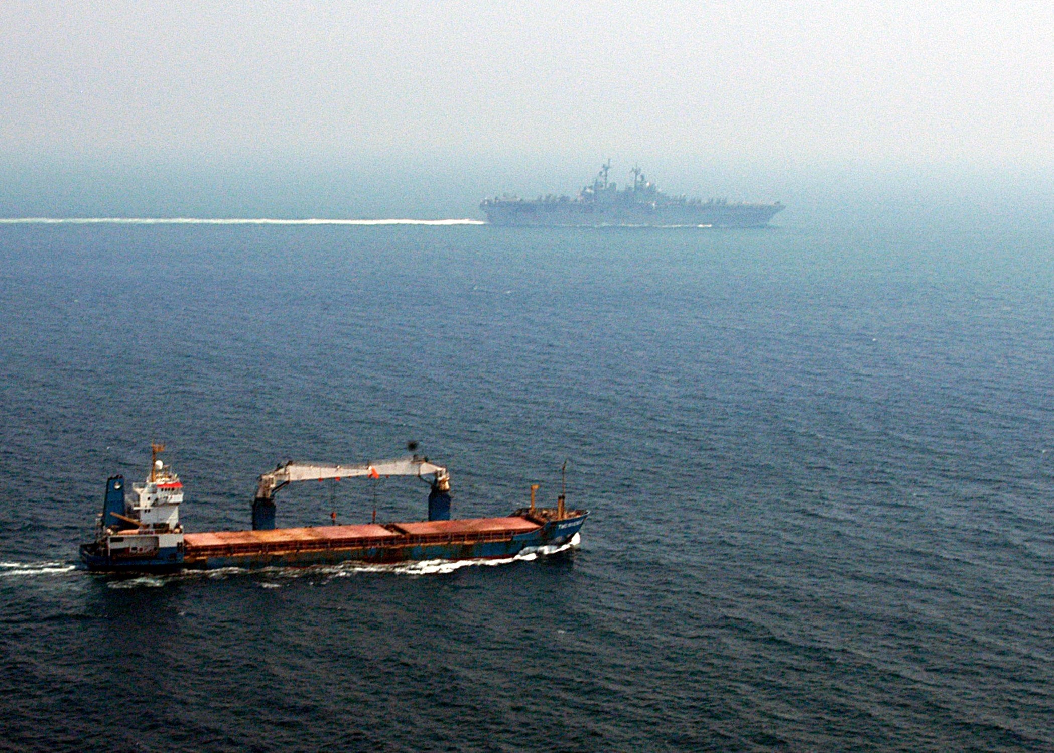 A merchant ship transits the Strait of Hormuz as a U.S. Navy vessel sails in the distance, July 5, 2004. U.S. Navy photo by Photographer’s Mate 3rd Class Angel Roman-Otero / Wikimedia Commons / Public Domain.