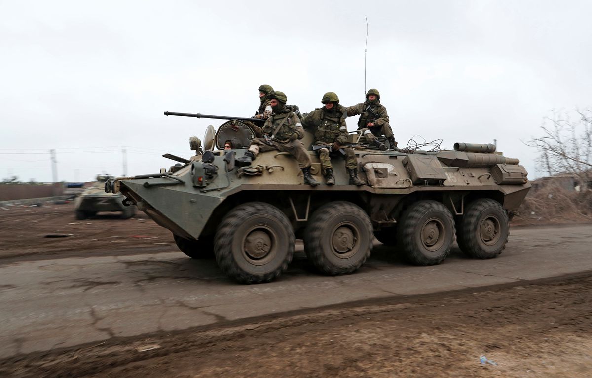 Service members of pro-Russian troops ride an armoured personnel carrier during Ukraine-Russia conflict on the outskirts of the southern port city of Mariupol, Ukraine