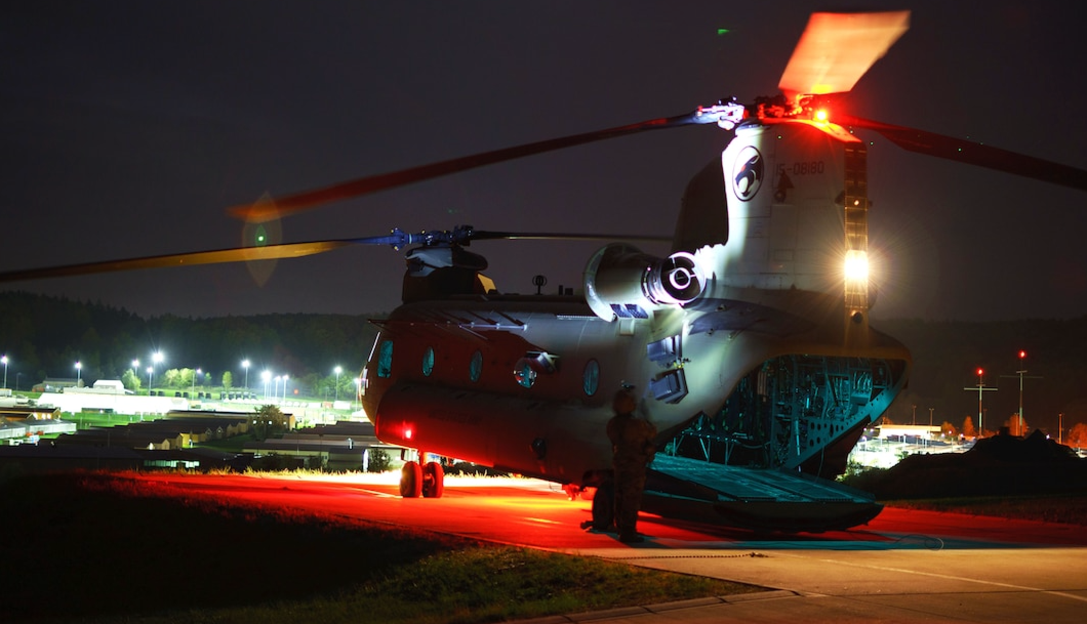 U.S. Army Staff Sgt. Fitz Hall shines a light on the tail of a CH-47 Chinook helicopter during pre-flight checks