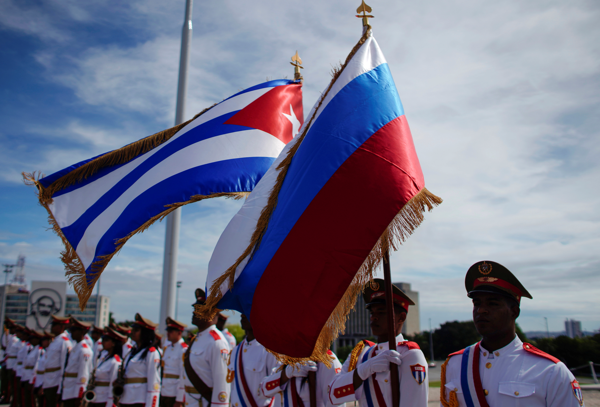 Honor guards hold a Russian and a Cuban flag during a wreath-laying ceremony with Russia's Prime Minister Dmitry Medvedev