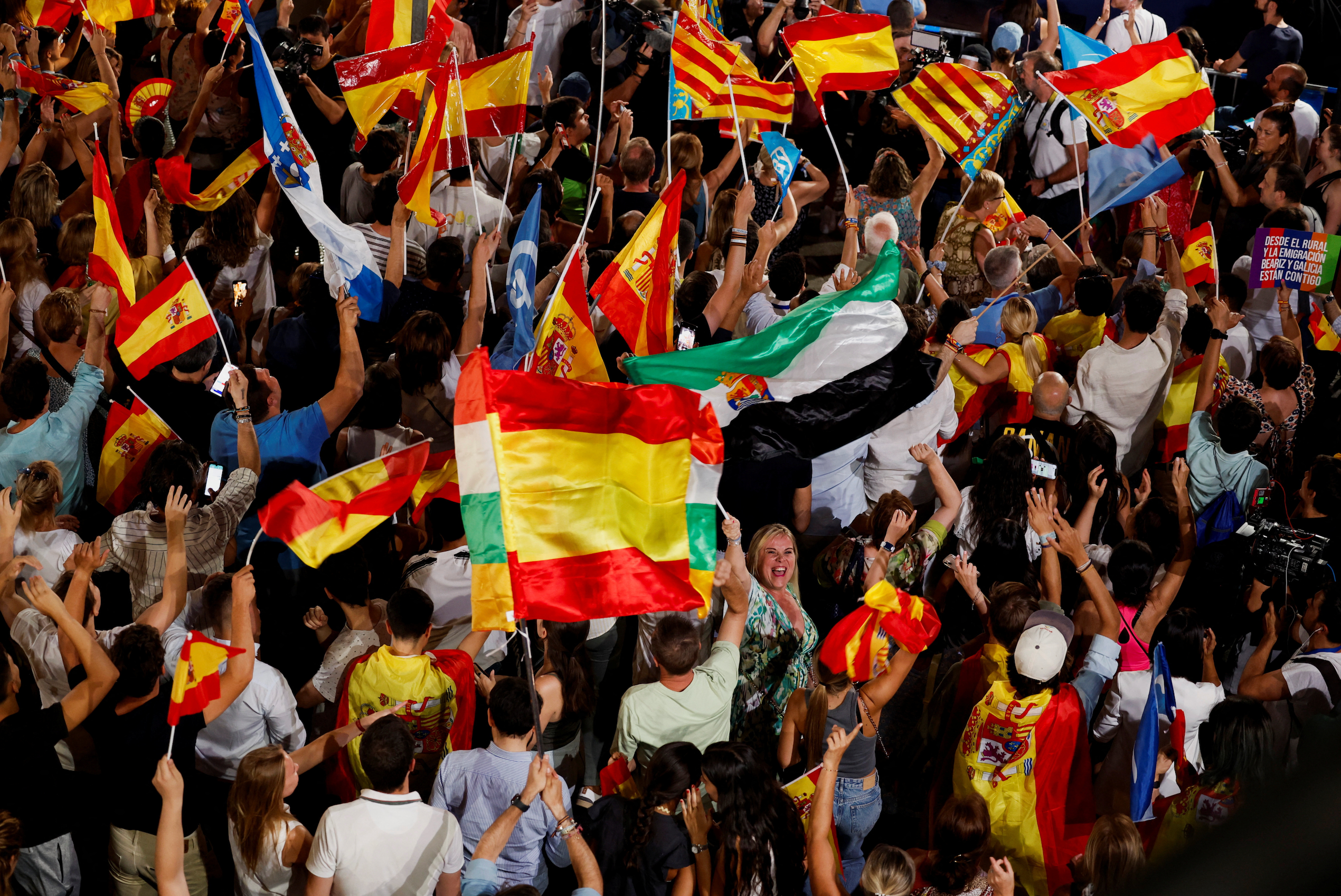 Supporters of Spain's opposition People's Party wave flags outside the party's headquarters