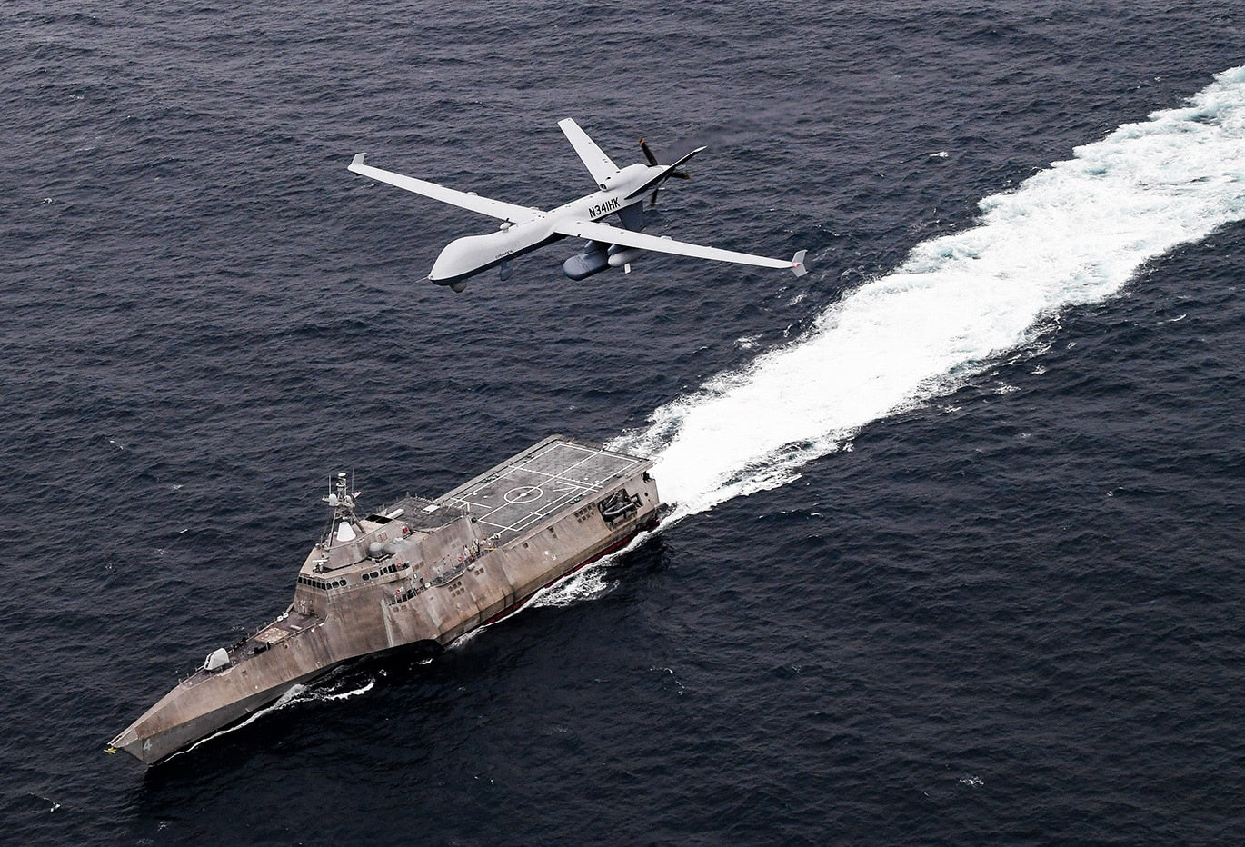 An MQ-9 SeaGuardian unmanned maritime surveillance aircraft system flies over Independence-variant littoral combat ship USS Coronado