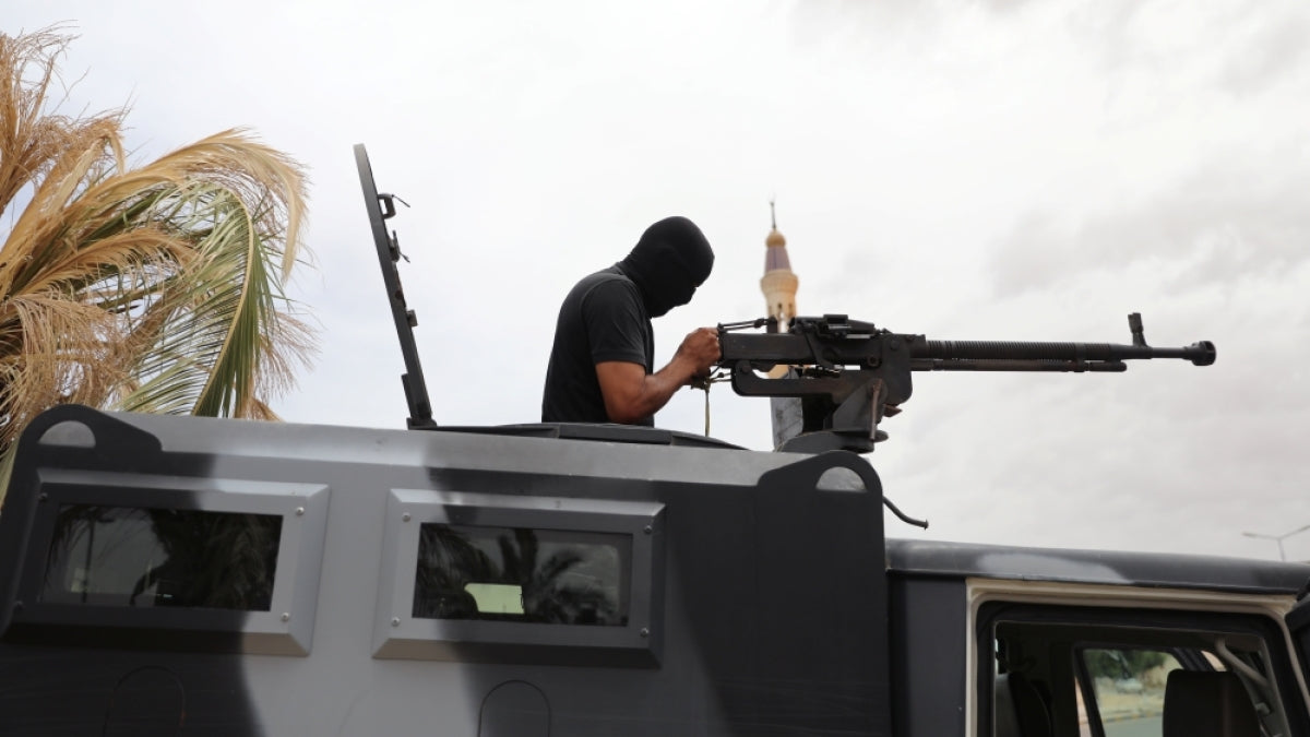 A member of security forces loyal to Libya’s government checks his weapon during a security deployment in Tarhuna city