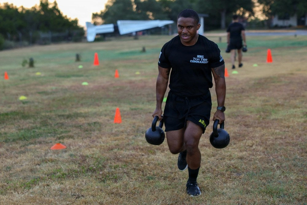 Texas Army National Guard Capt. Brandon Brown carries kettlebells during the Army Fitness Test in Austin, Texas, on Aug. 16, 2026. The current AFT uses equipment including kettlebells, a weighted sled and deadlift weights. U.S. Army photo by Spc. Robert