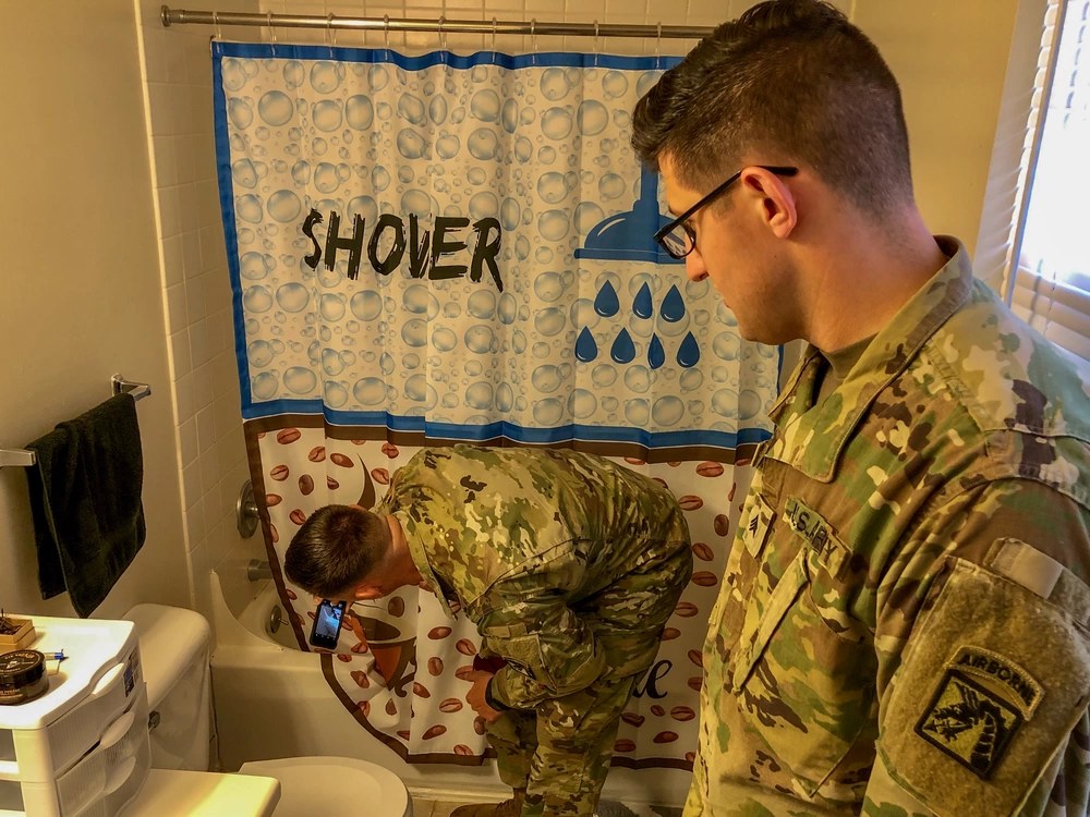 1st Sgt. Jeremy Crisp and Sgt. Andrew McNeil inspect maintenance issues inside a Fort Bragg barracks bathroom on April 5, 2019. The image is illustrative of barracks maintenance conditions and does not depict the current 2026 plumbing-policy discrepancy.