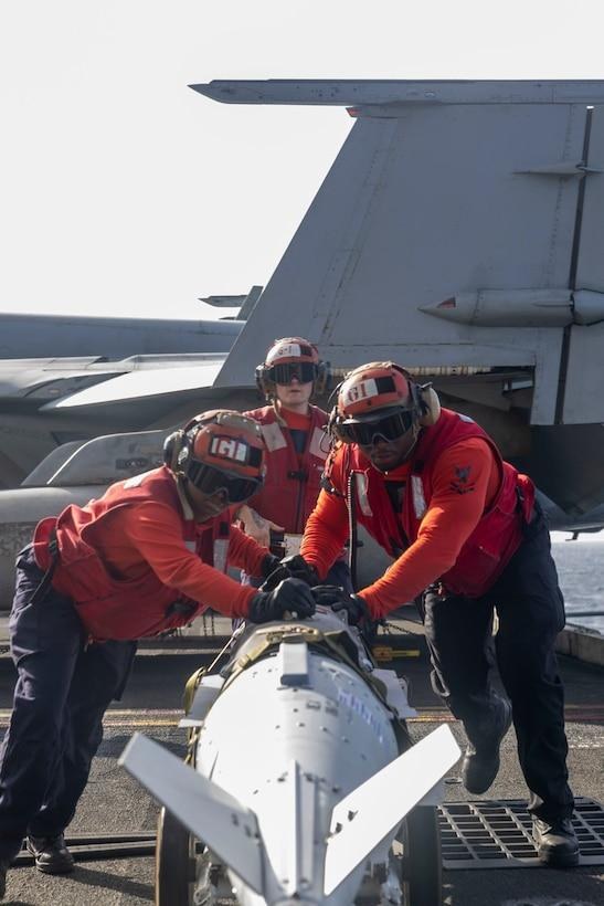 U.S. Navy sailors prepare ordnance aboard USS Harry S. Truman during operations in the U.S. Central Command region. New reporting says Pentagon officials had warned before the expanded Houthi campaign that prolonged strikes could strain key U.S.
