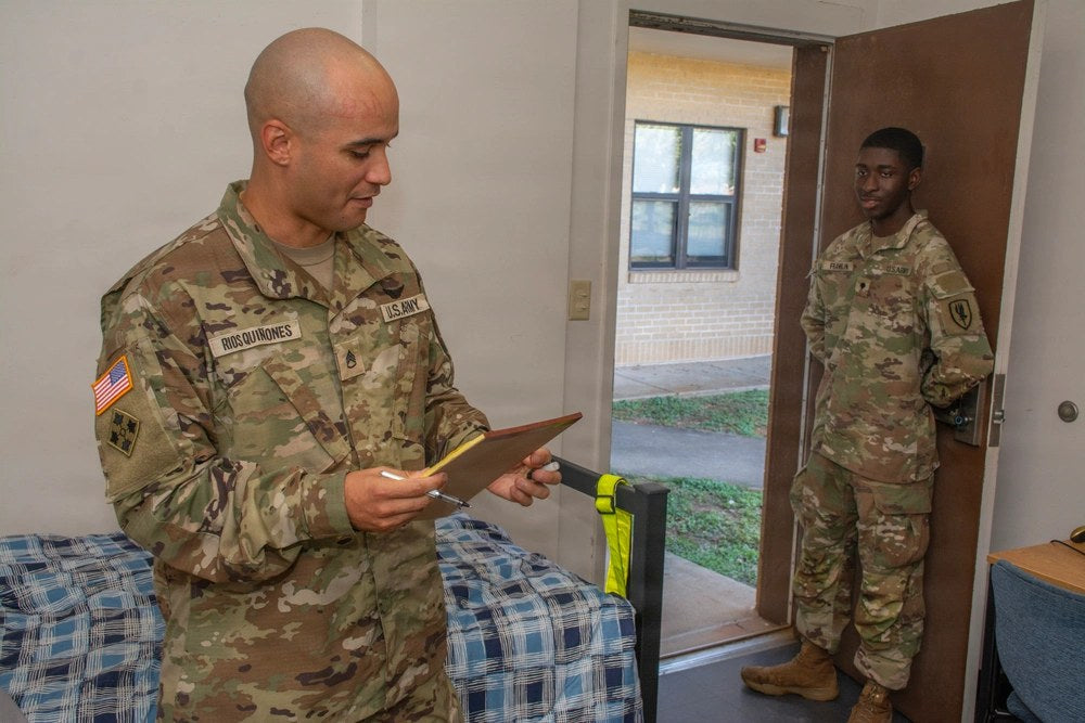 An Army NCO reviews notes during a barracks room inspection as a soldier stands in the doorway at Fort Rucker, Alabama, Sept. 17, 2026. U.S. Army photo by John Drew Hamilton.