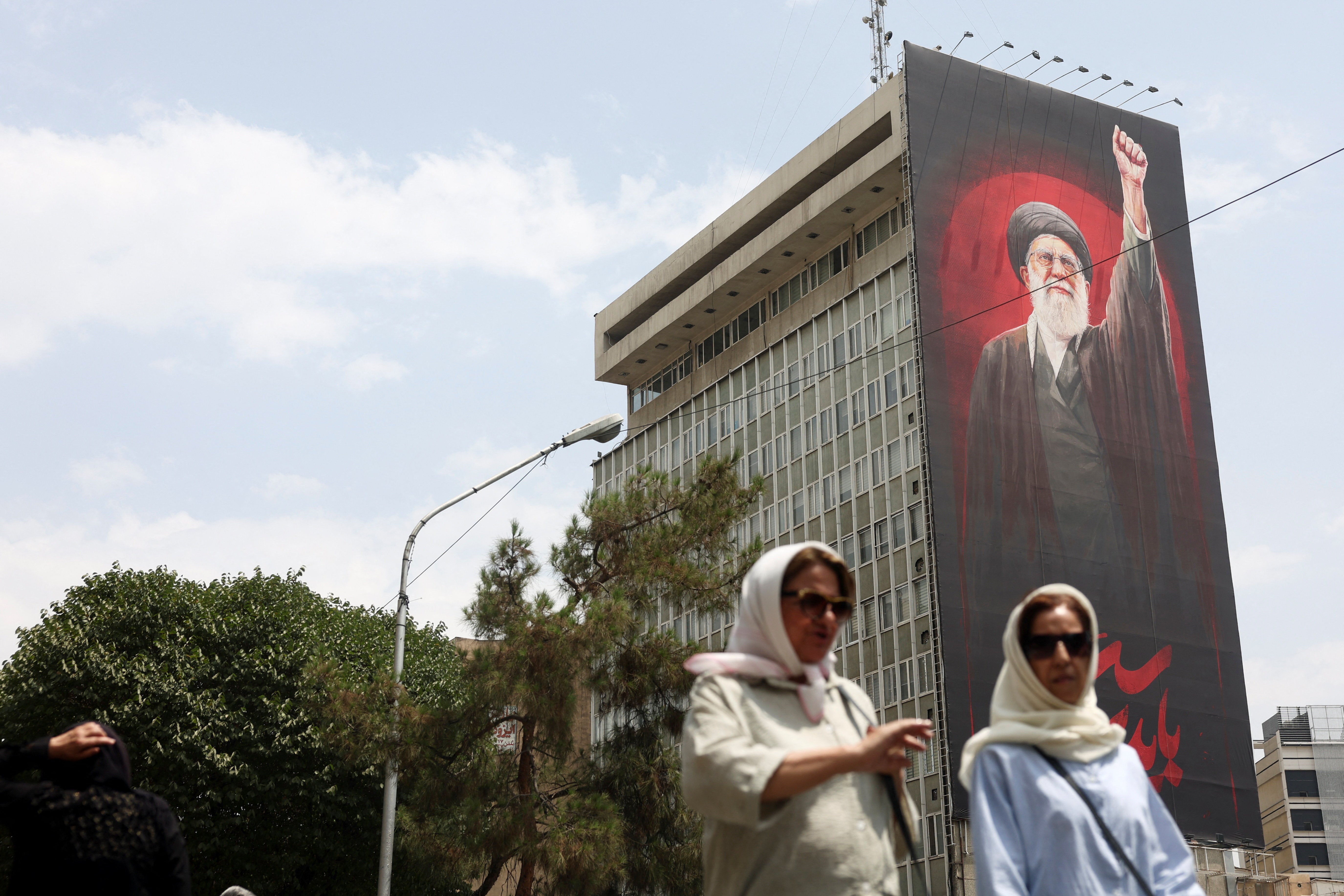 People walk near a billboard depicting Iran's late Supreme Leader Ayatollah Ali Khamenei, on a street in Tehran, Iran, August 3, 2026. Majid Asgaripour/WANA (West Asia News Agency) via REUTERS