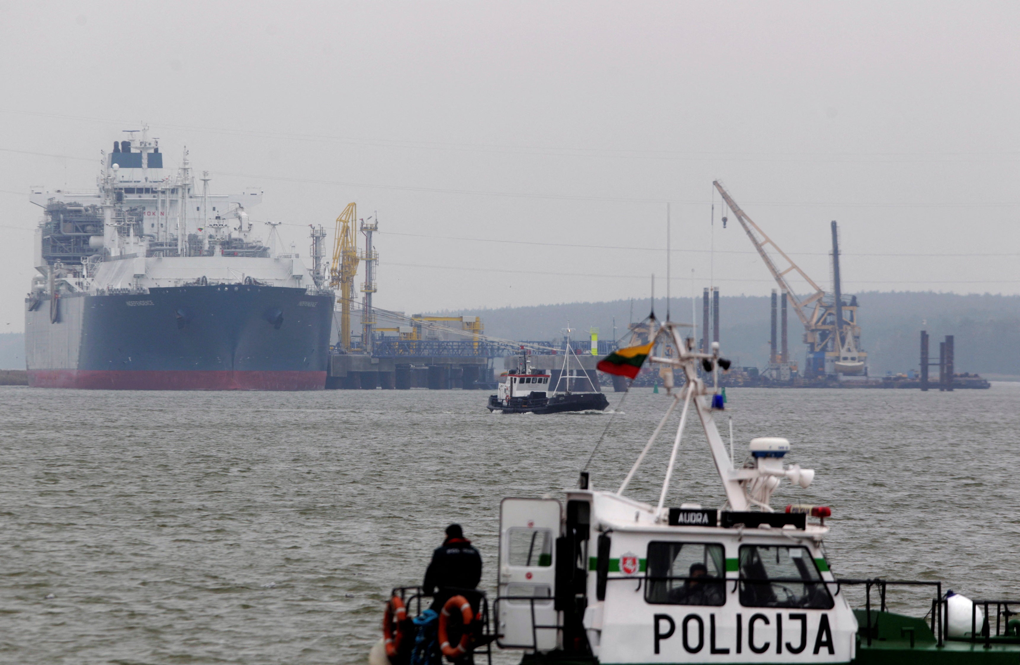 FILE PHOTO: A police boat is seen in the foreground of the floating storage regasification unit "Independence" on October 27, 2014, one of the key infrastructure objects in Lithuania now guarded by military due to fears of a Russian false-flag attack.