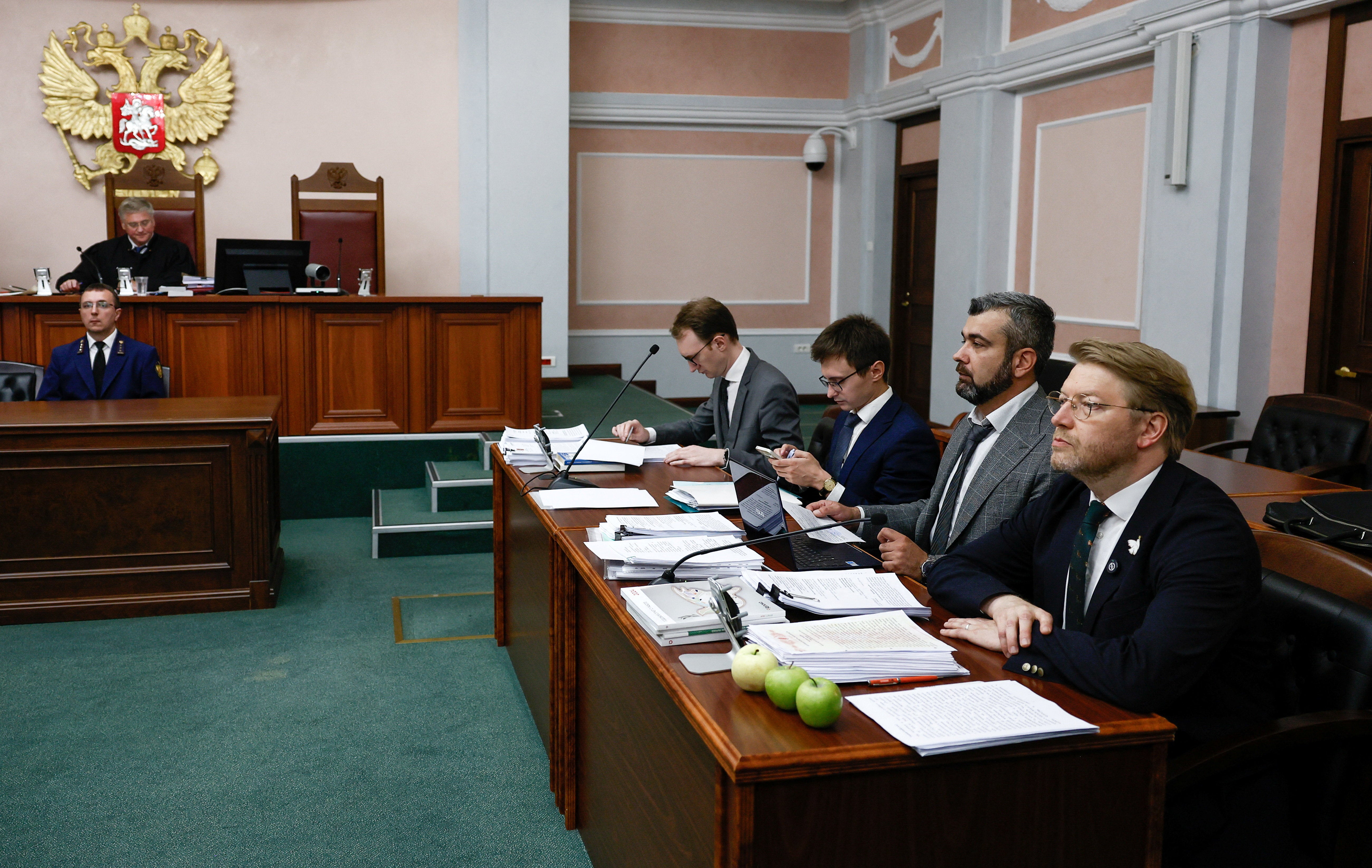 Chairman of Russia's Yabloko political party Nikolai Rybakov sits next to lawyers during a hearing of the Supreme Court held to consider a lawsuit to bar the party from contesting the September parliamentary elections on the basis of alleged violations,