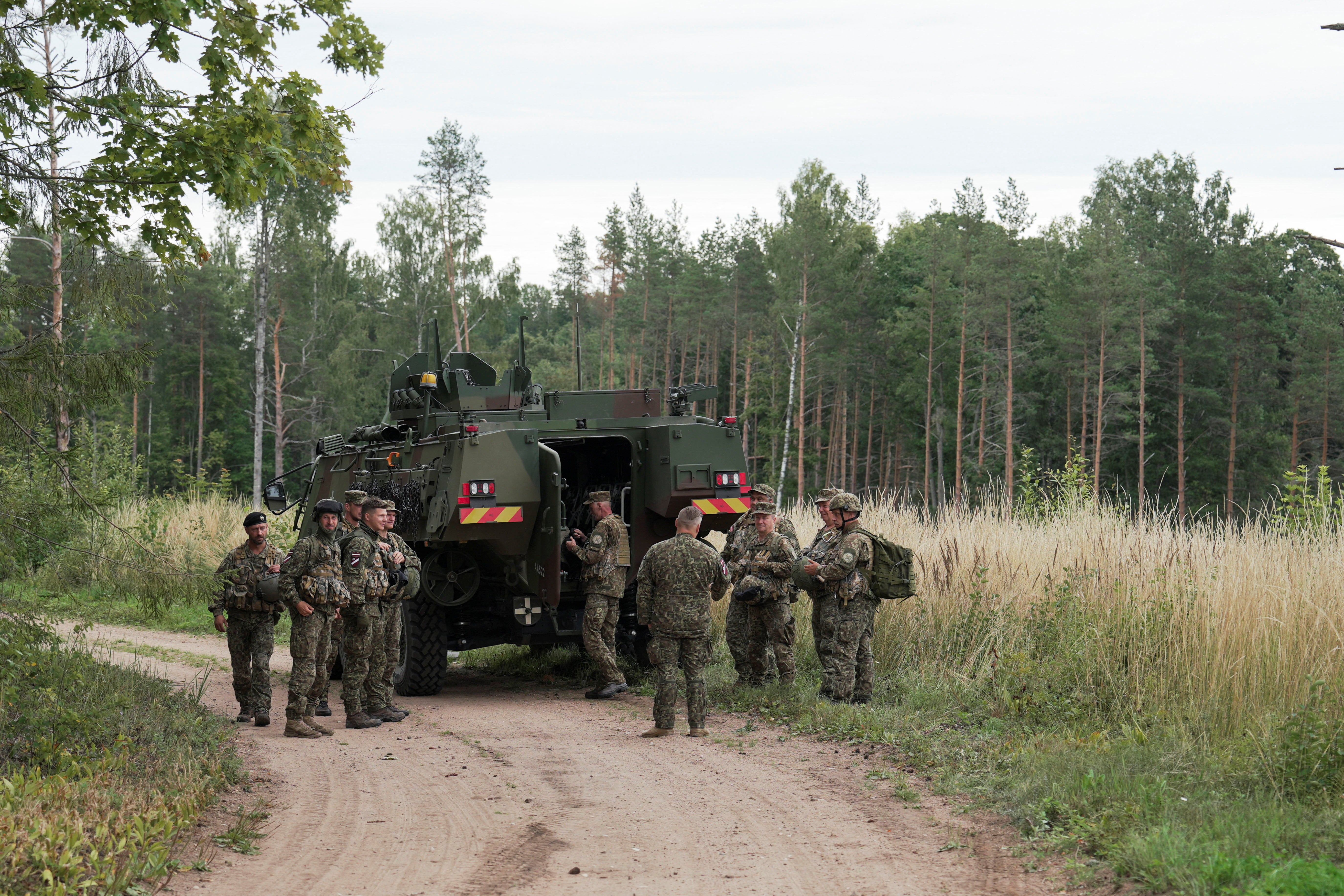Servicemen of the Latvian National Guard gather before a search operation for the debris from an intercepted drone, amid Russia's attack on Ukraine, in Rugaji, Latvia, August 14, 2026. REUTERS/Janis Laizans