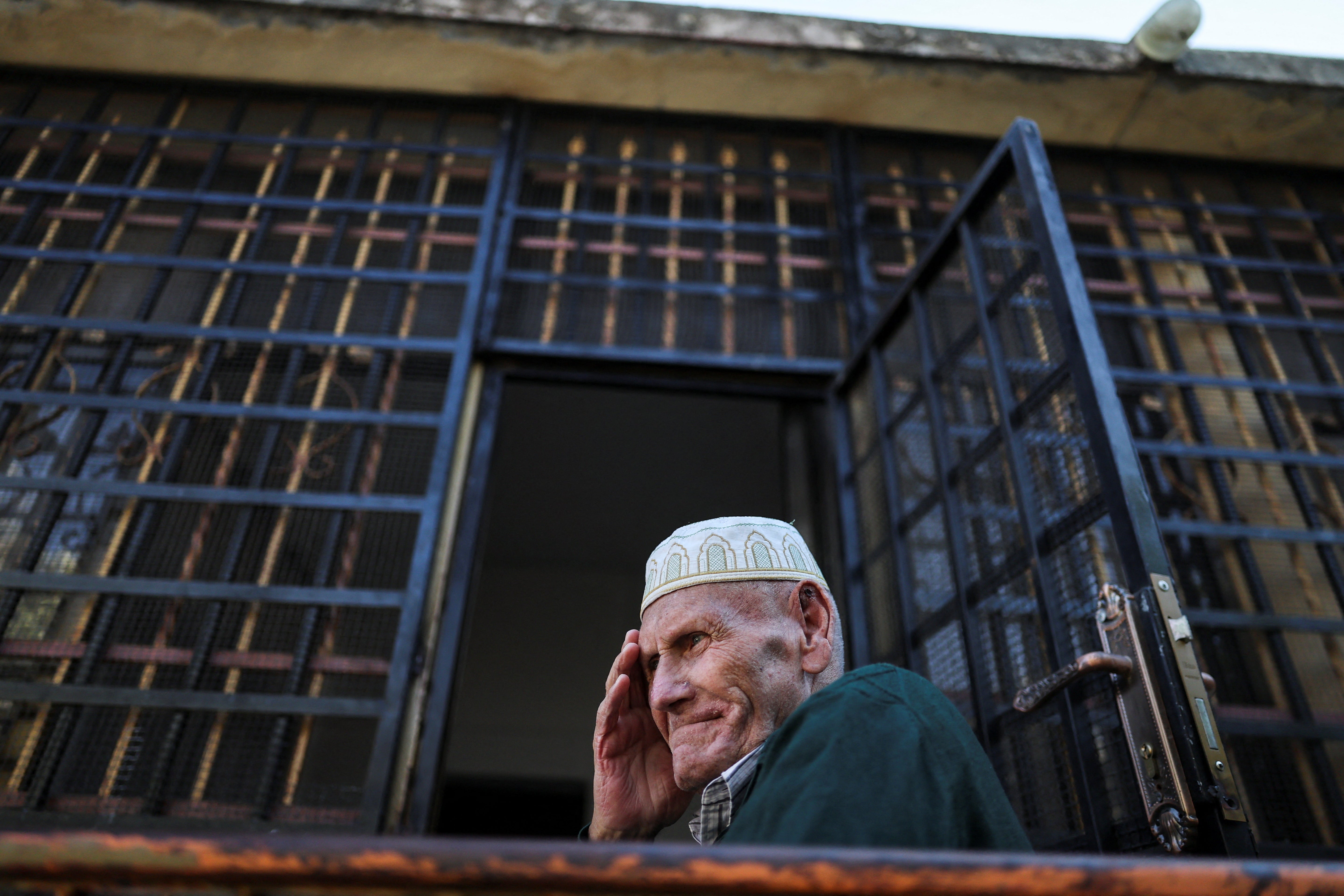 Palestinian grandfather Yousef Foqahaa sits outside his family home, whose windows they barred after Israeli settlers threw a Molotov cocktail inside two years ago while the family was home, in Sinjil, near Ramallah, in the Israeli-occupied West Bank,