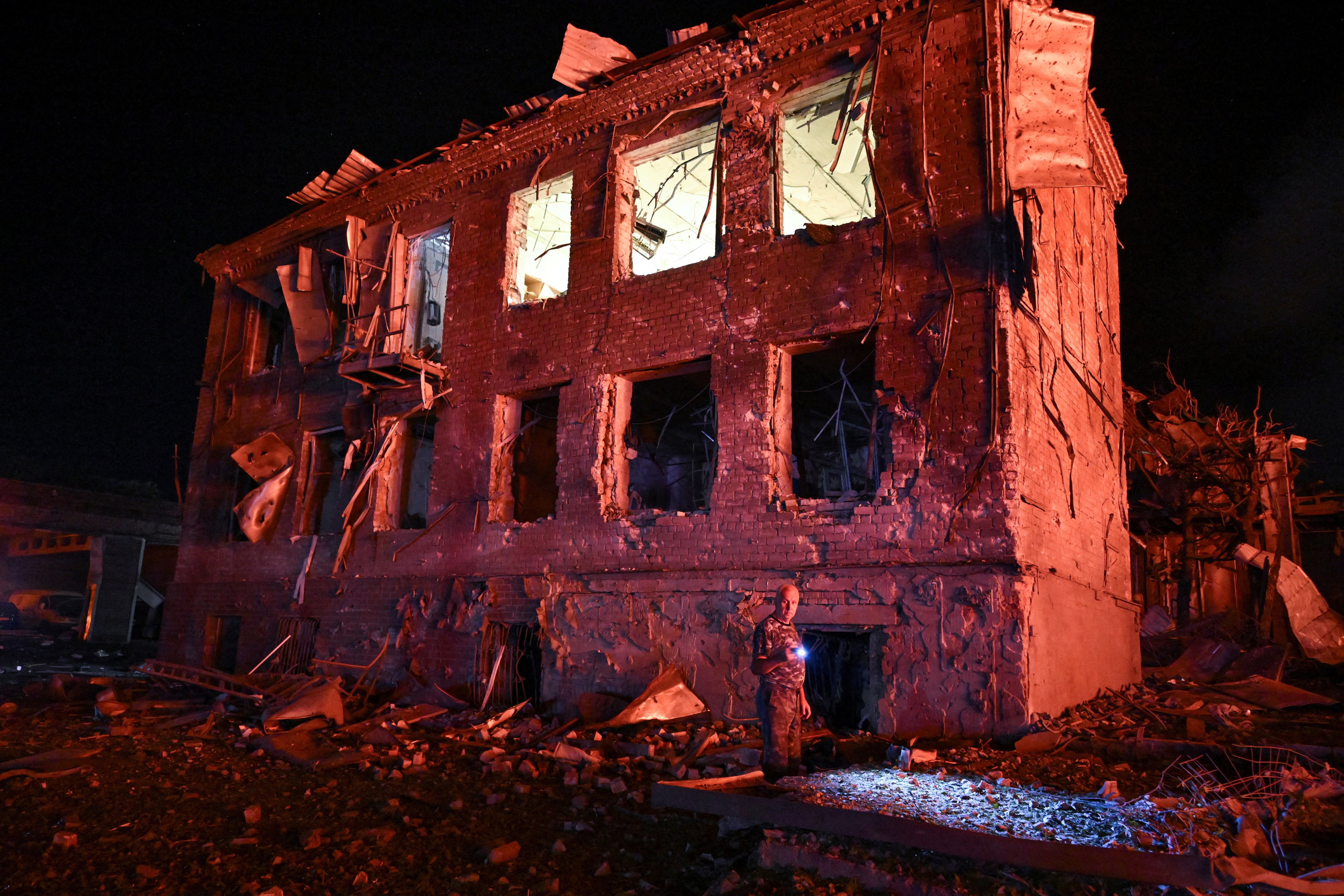 A resident stands next to a building damaged by an overnight Russian missile strike, amid Russia's attack on Ukraine, in Zaporizhzhia, Ukraine August 11, 2026. REUTERS/Stringer     TPX IMAGES OF THE DAY