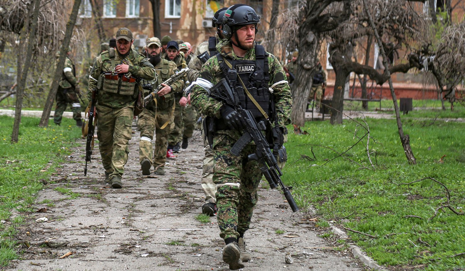 Fighters of a Chechen special forces unit walk in a courtyard in Mariupol, Ukraine